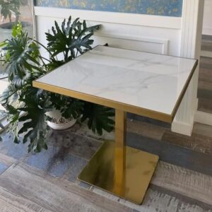 Table carrée en quartz artificiel avec bordure dorée et pied central doré